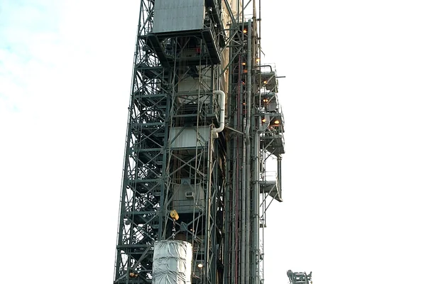KENNEDY SPACE CENTER, FLA.  -  After dawn,  the Space Infrared Telescope Facility (SIRTF) is lifted up the mobile service tower on Launch Pad 17-B, Cape Canaveral Air Force Station.  SIRTF will be attached to the Delta II rocket and encapsulated in its fairing before launch.   Consisting of three cryogenically cooled science instruments and an 0.85-meter telescope, SIRTF is one of NASA’s largest infrared telescopes to be launched.  It is the fourth and final element in NASA’s family of orbiting “Great Observatories.”  SIRTF will obtain images and spectra by detecting the infrared energy, or heat, radiated by objects in space. Most of this infrared radiation is blocked by the Earth's atmosphere and cannot be observed from the ground.