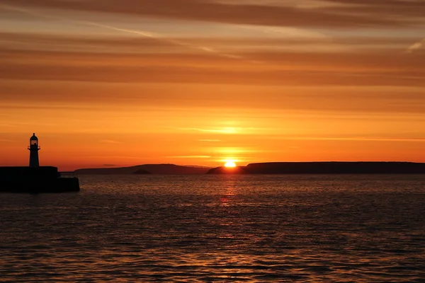 Sunrise, golden hour, St. Ives harbour, lighthouse, Cornwall.