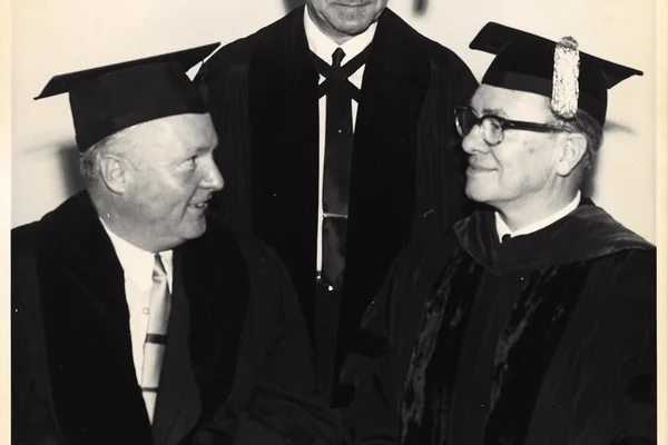 Mayor John F. Collins wearing graduation cap with two unidentified men, also wearing graduation caps