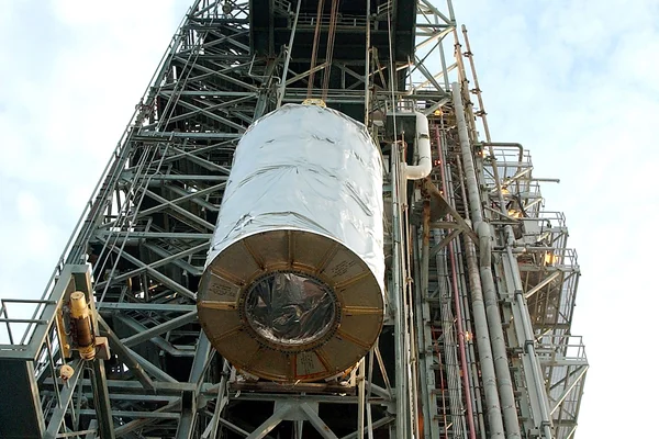 KENNEDY SPACE CENTER, FLA.  -  Viewed from below, the Space Infrared Telescope Facility (SIRTF) is lifted up the mobile service tower on Launch Pad 17-B, Cape Canaveral Air Force Station.  SIRTF will be attached to the Delta II rocket and encapsulated in its fairing before launch.   Consisting of three cryogenically cooled science instruments and an 0.85-meter telescope, SIRTF is one of NASA’s largest infrared telescopes to be launched.  It is the fourth and final element in NASA’s family of orbiting “Great Observatories.”  SIRTF will obtain images and spectra by detecting the infrared energy, or heat, radiated by objects in space. Most of this infrared radiation is blocked by the Earth's atmosphere and cannot be observed from the ground.