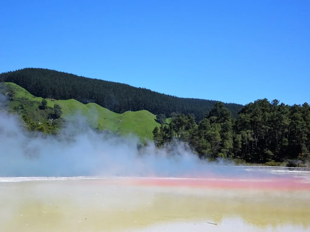 Rotorua. The sulphur coloured edge of Champagne Lake in the geothermal volcanic park of Wai O Tapu. Boiling steam rises from the lake.